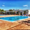 Piscina con sdraio e ombrelloni.