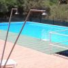 Piscina all'aperto con docce e sedie a sdraio.