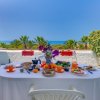 Tavola apparecchiata per colazione all'aperto con vista mare.