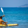 Persona su un kayak giallo in mare calmo.